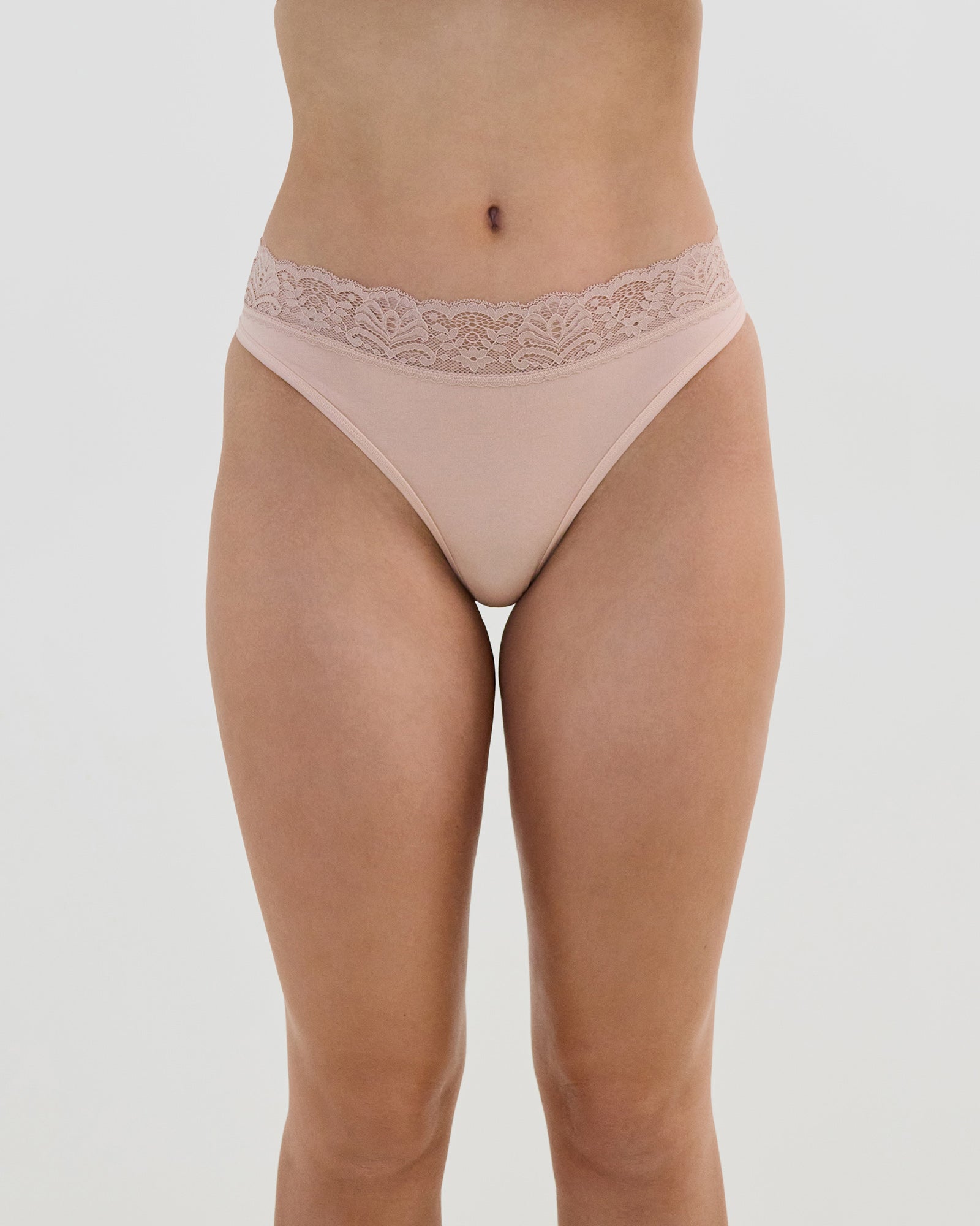 Model wears Cotton And Lace Thong in LATTE. On body front view