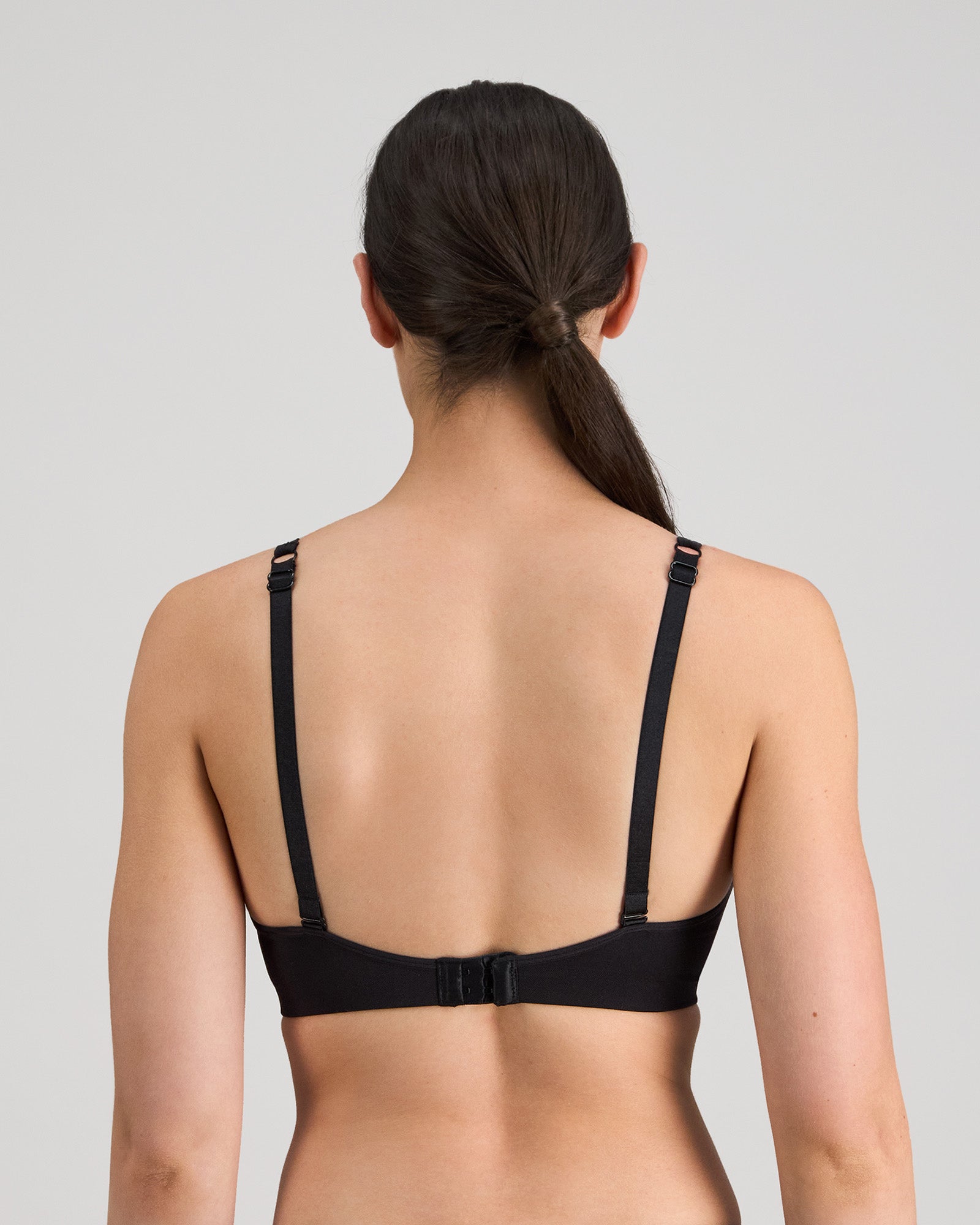 Model wears Simply Seamless Wire Free Bra in BLACK. On body back view