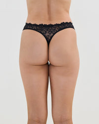 Model wears All Lacey Thong in BLACK. On body back view