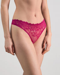 Model wears All Lacey Thong in FANTASY FUCHSIA. On body side view