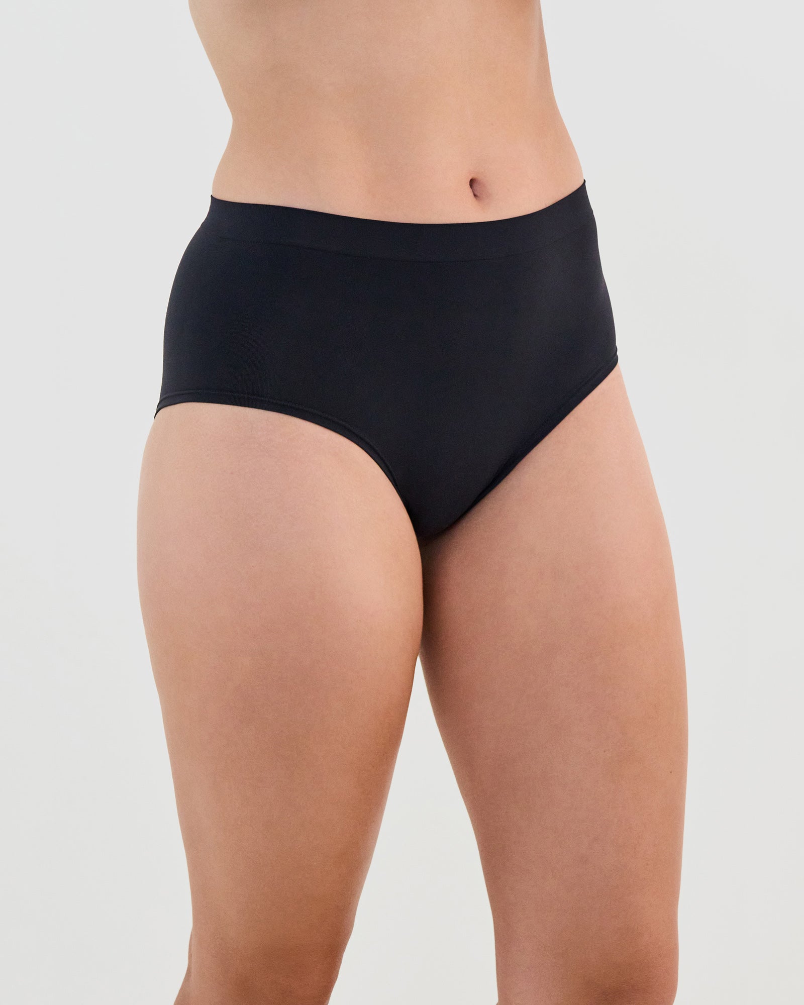 Model wears Seamless Soft Full Brief in BLACK. On body side view