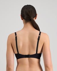 Model wears Simply Seamless Contour Bra in BLACK. On body back view