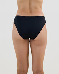 Model wears Lacey Bikini in BLACK. On body back view