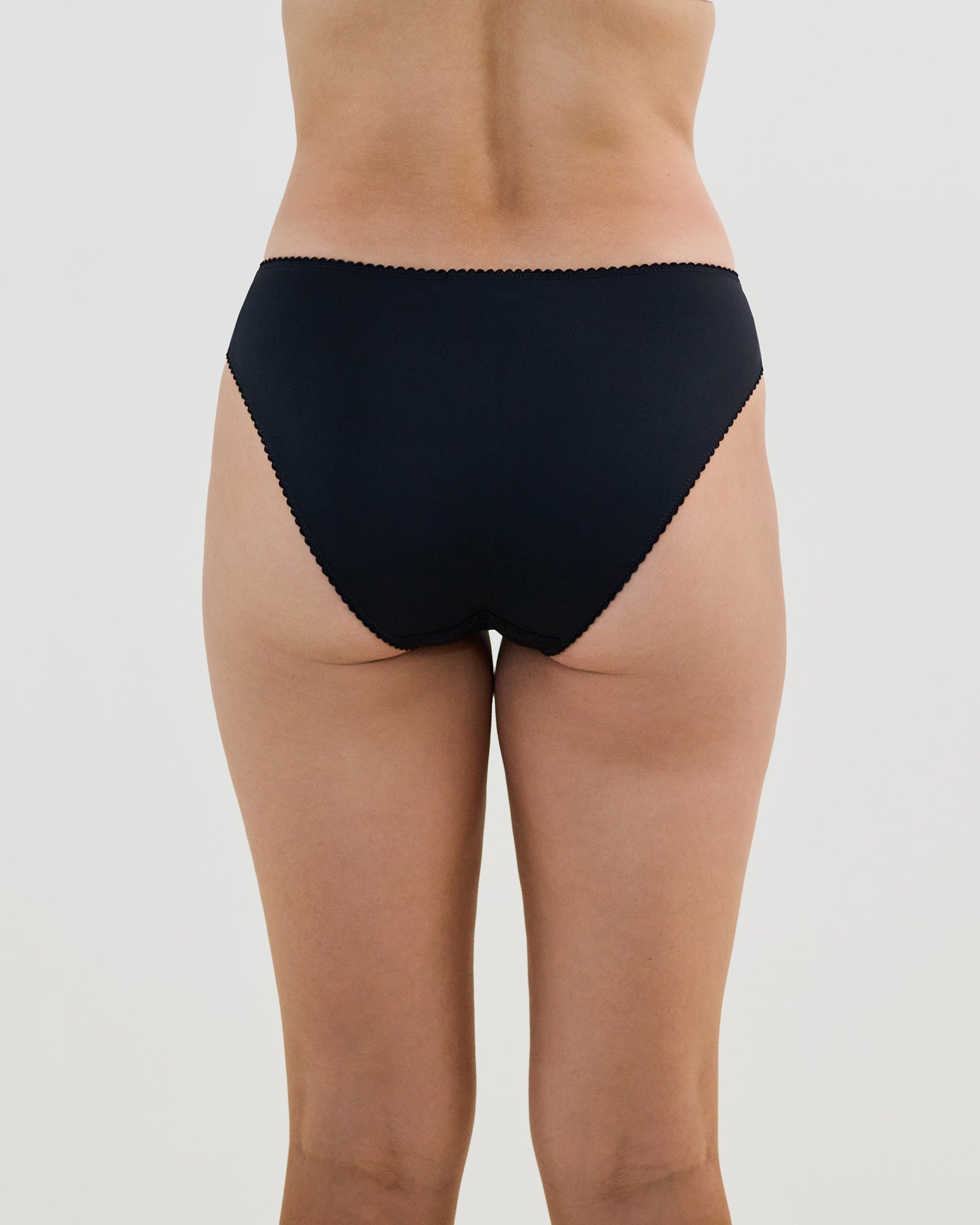 Model wears Lacey Bikini in BLACK. On body back view