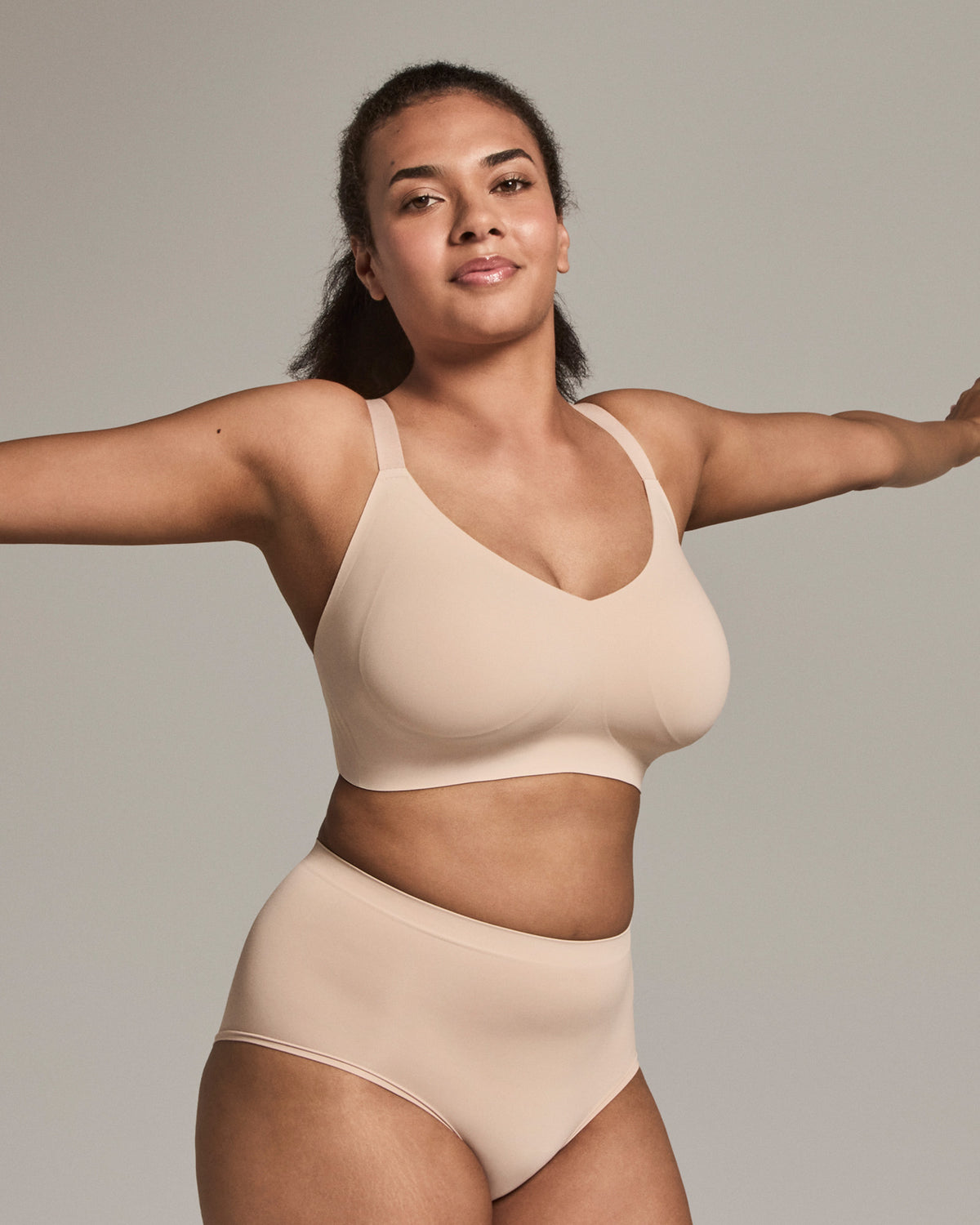 Woman wearing a beige bikini set against a plain background
