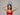 Woman wearing a red bralette holding a sparkly handbag above her head against a gray background