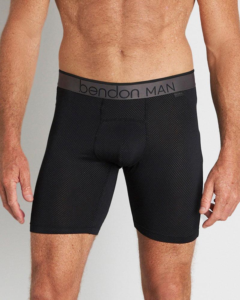 Model wears Everyday Active Mens Long Trunk in BLACK. On body front view