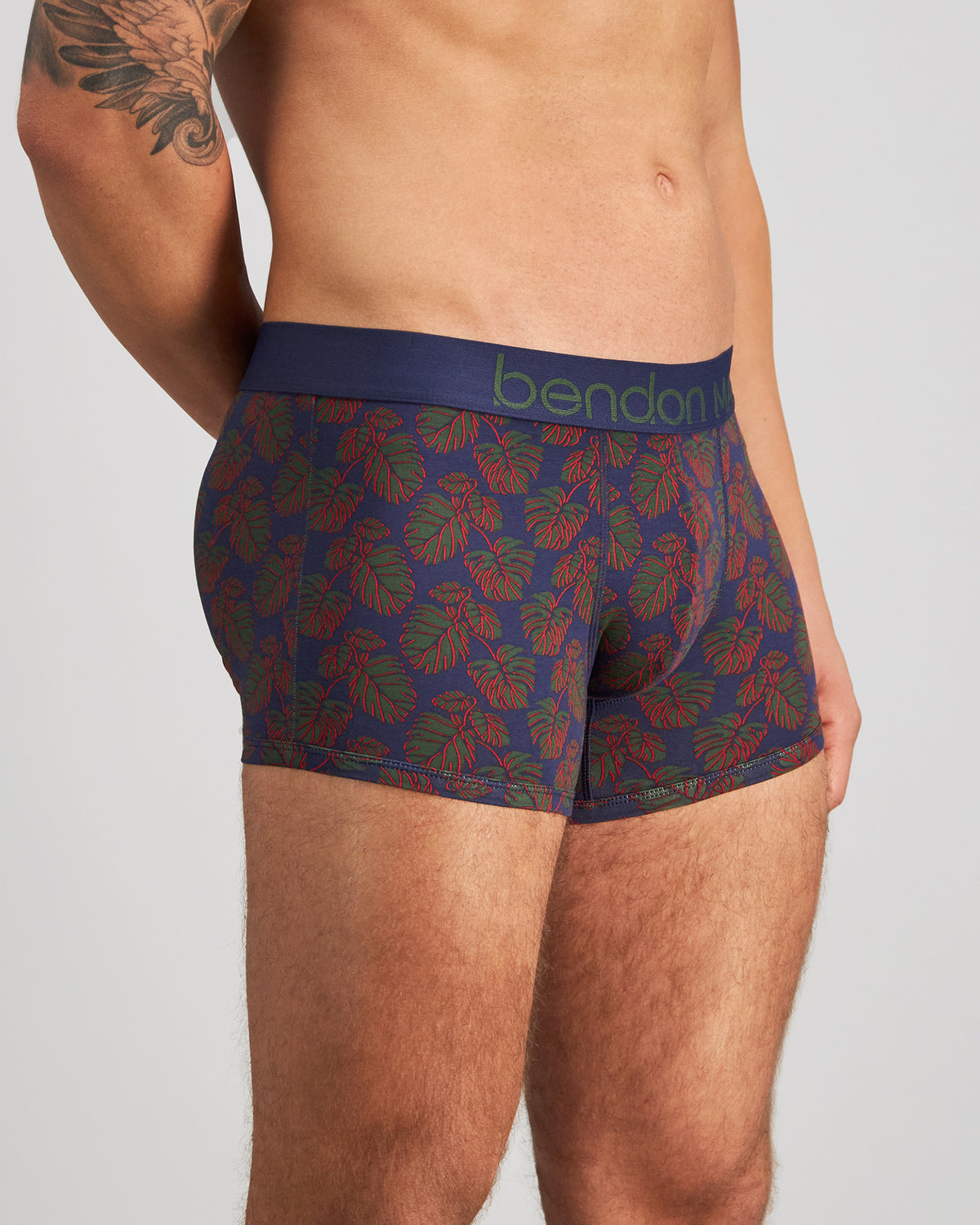 Model wears Retros Print Mens Trunk in BOLD MONSTERA PRINT. On body side view