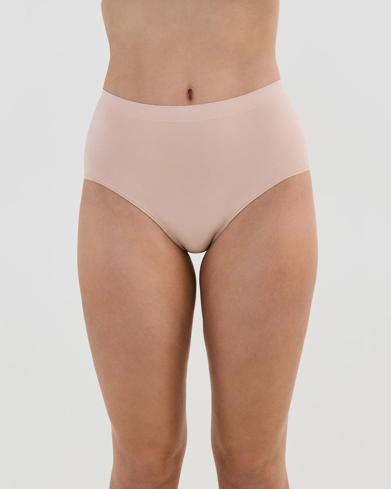 Model wears Seamless Soft Full Brief in LATTE. On body front view