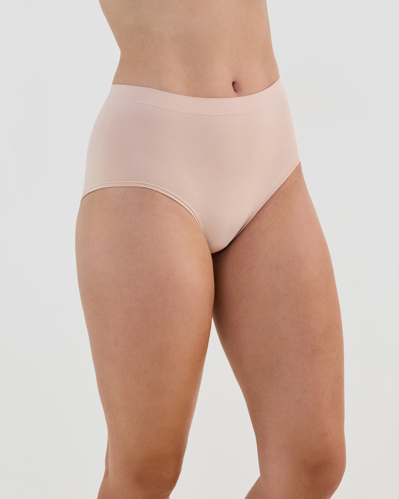 Model wears Seamless Soft Full Brief in LATTE. On body side view