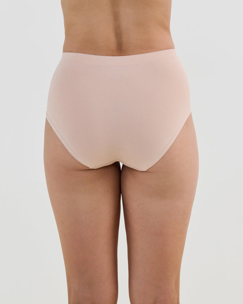 Model wears Seamless Soft Full Brief in LATTE. On body back view
