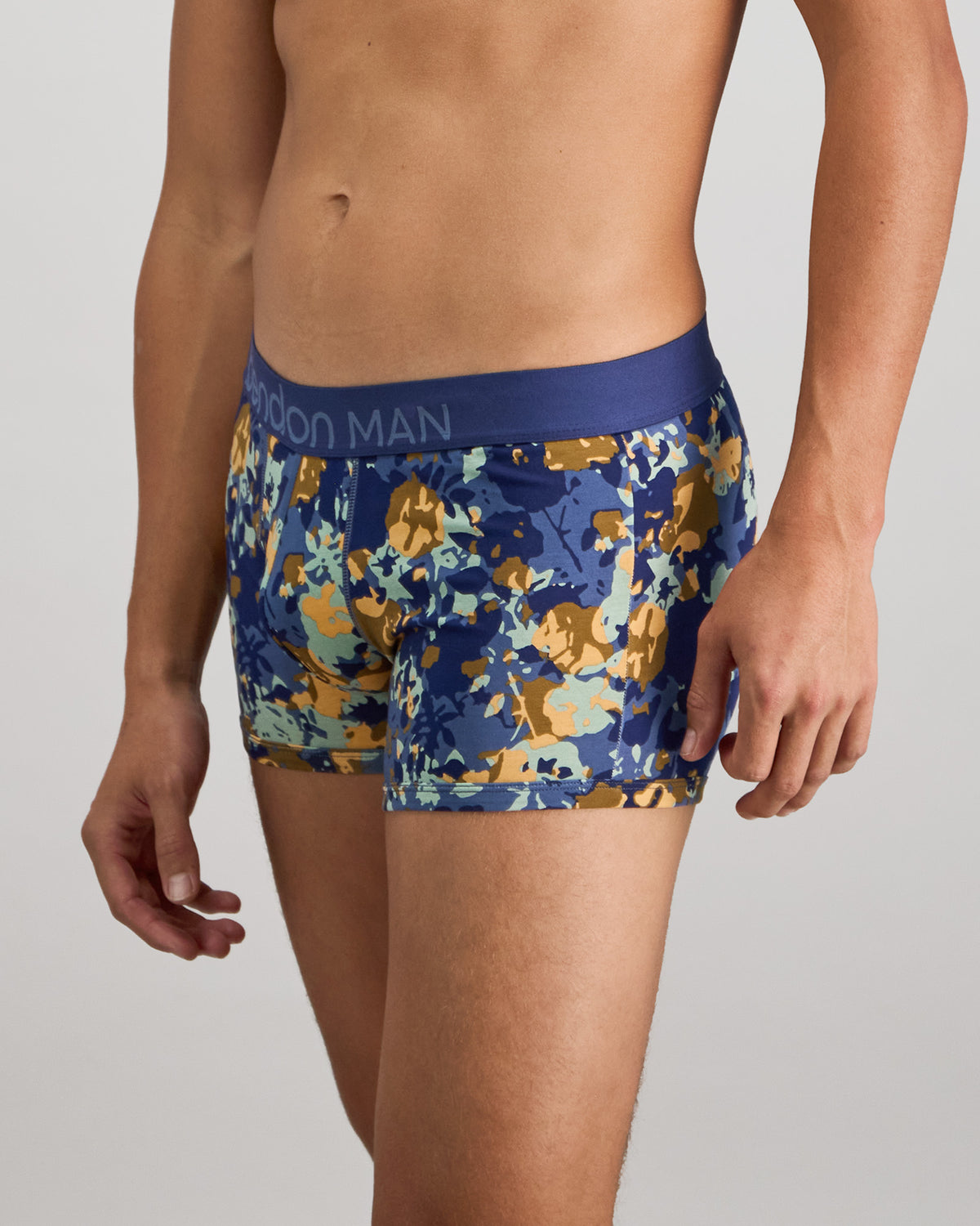 Model wears Retros Print Mens Trunk in WILD CAMO PRINT. On body side view