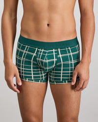 Model wears Retros Print Mens Trunk in RAIN FOREST GRID PRINT. On body front view