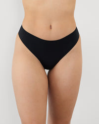 Model wears Au Naturel Thong in BLACK. On body front view