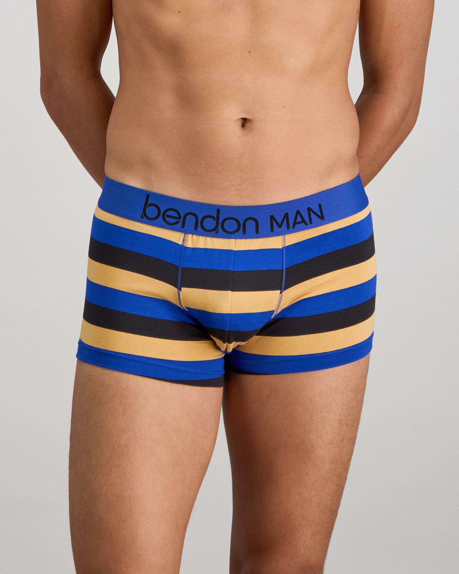 Model wears Rugby Stripe Mens Trunk in BLACK/SURF/OAK BUFF. On body front view