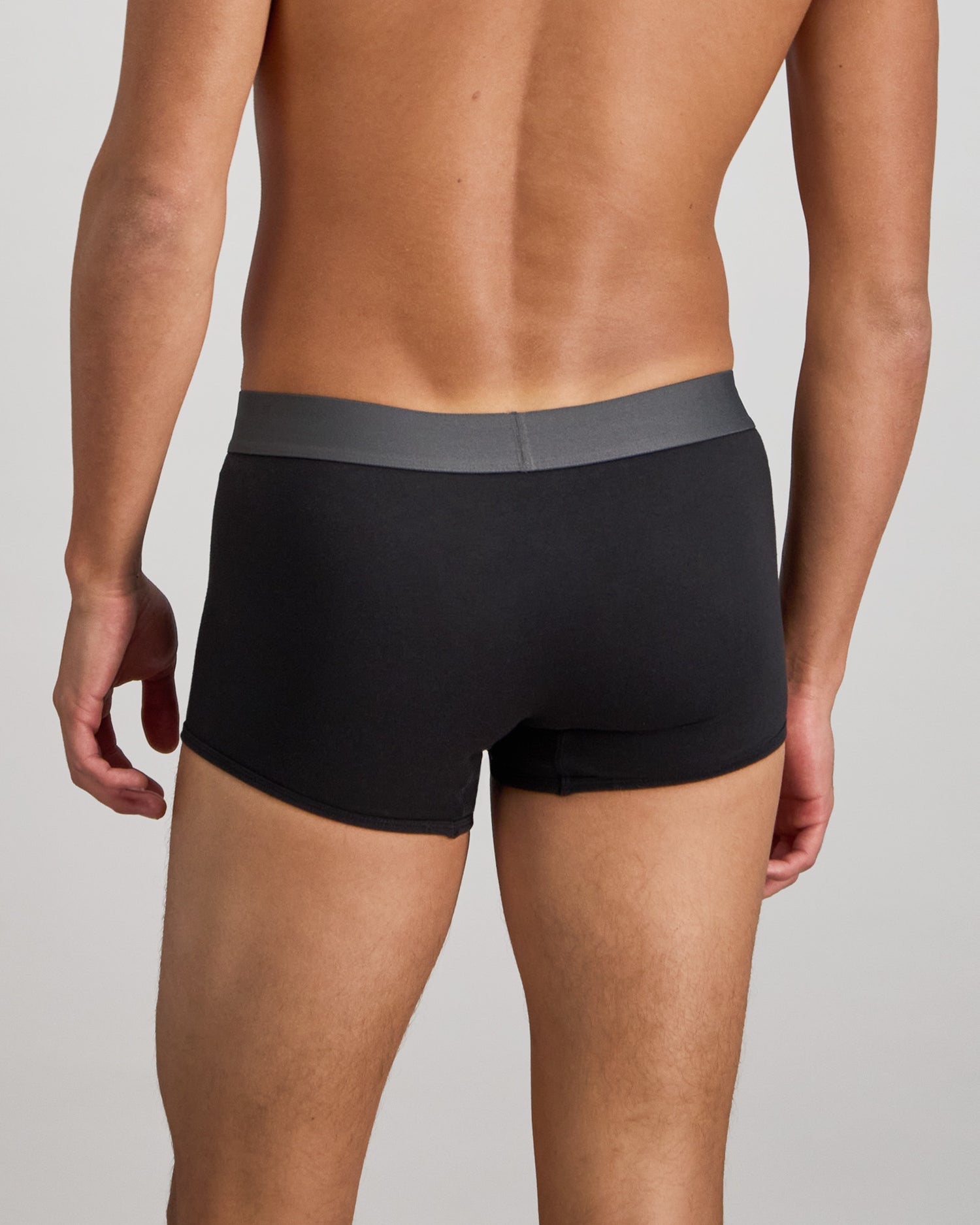 Model wears Cotton Low-Rise Mens Trunk in BLACK. On body back view