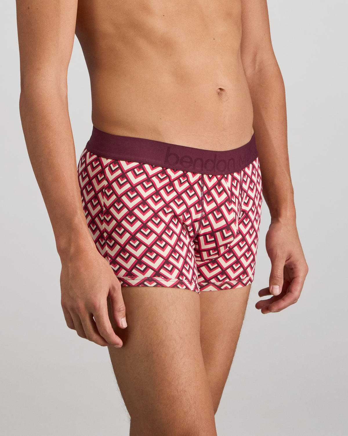 Model wears Retros Print Mens Trunk in ART TILE PRINT. On body side view