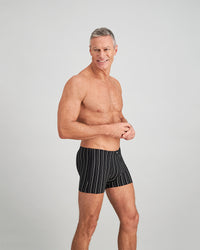 Model wears Cotton Stretch Mens Trunk in BLACK WHITE. On body side view