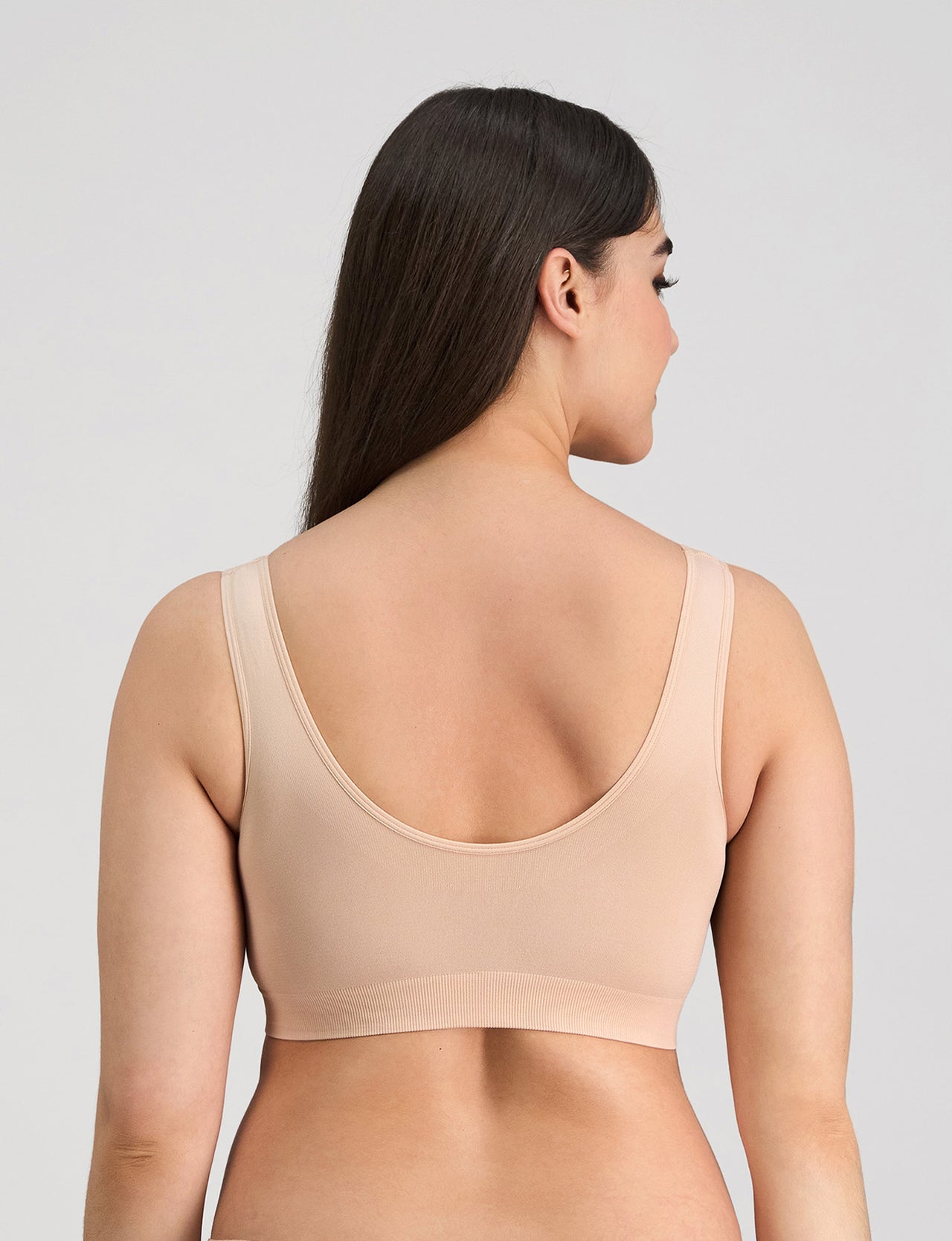 Model wears Bendon Essentials Strapless Bra in LATTE. On body back view
