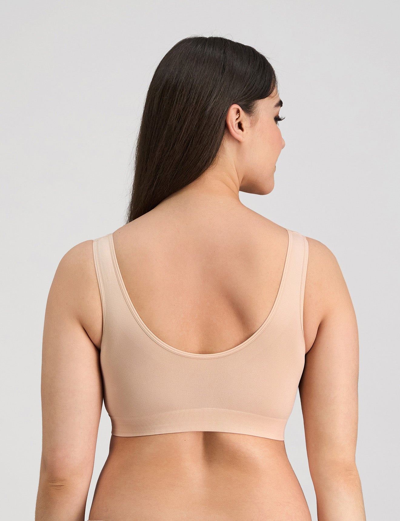 Model wears Bendon Essentials Strapless Bra in LATTE. On body back view