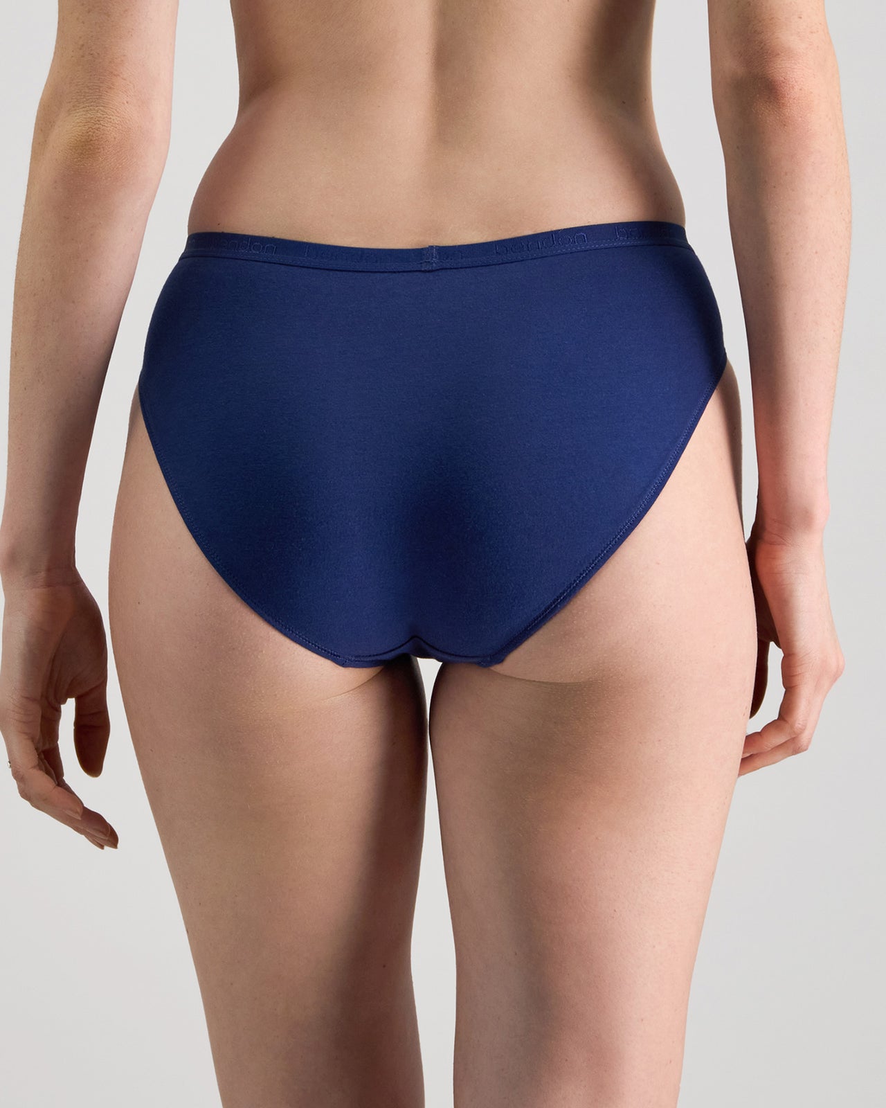 Model wears Body Cotton High Cut Brief in Medieval Blue. On body back view