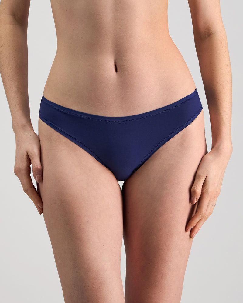 Model wears Extra-Ordinary Thong in Medieval Blue. On body front view