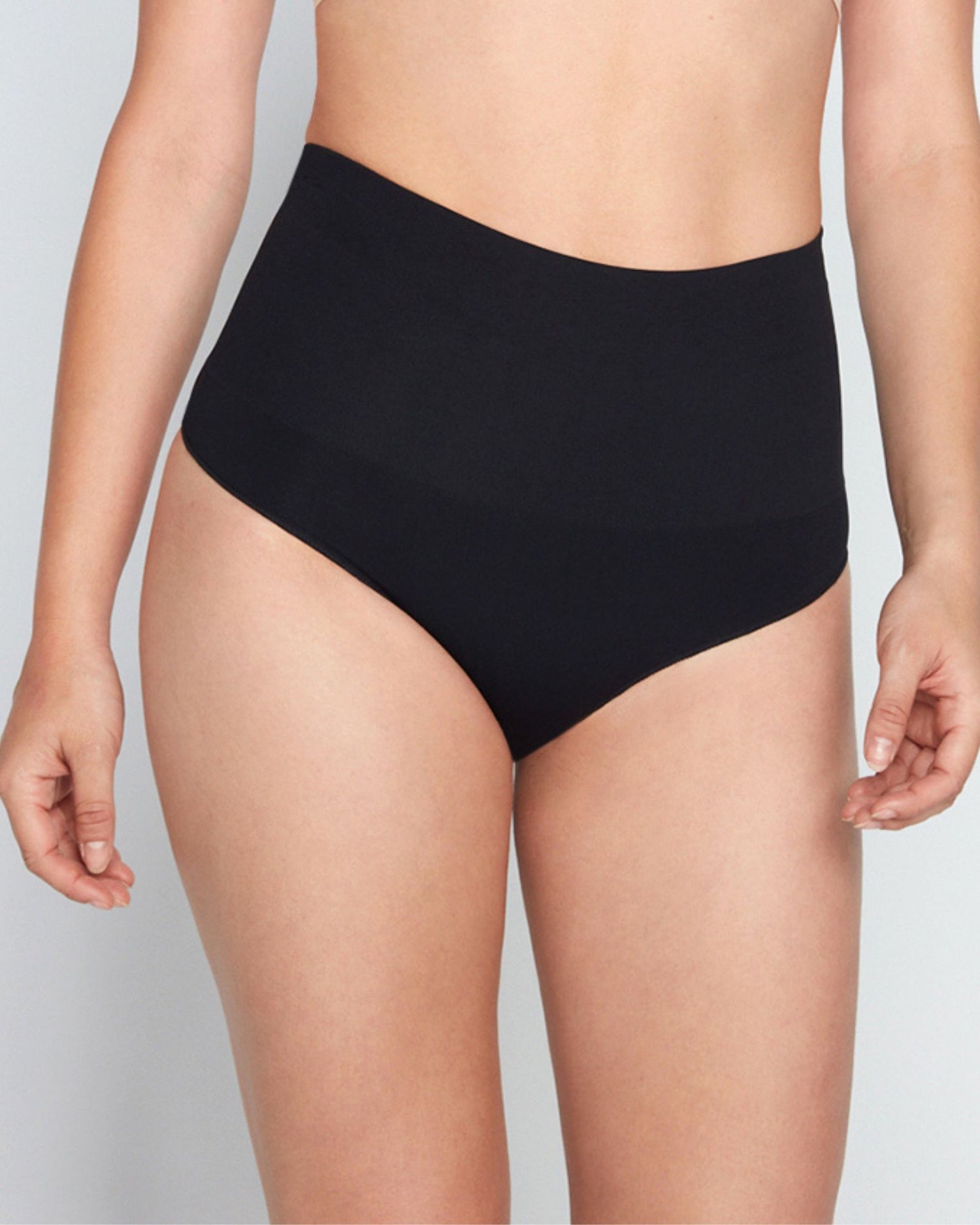 Model wears Bamboo Bodywear Thong in BLACK. On body front view