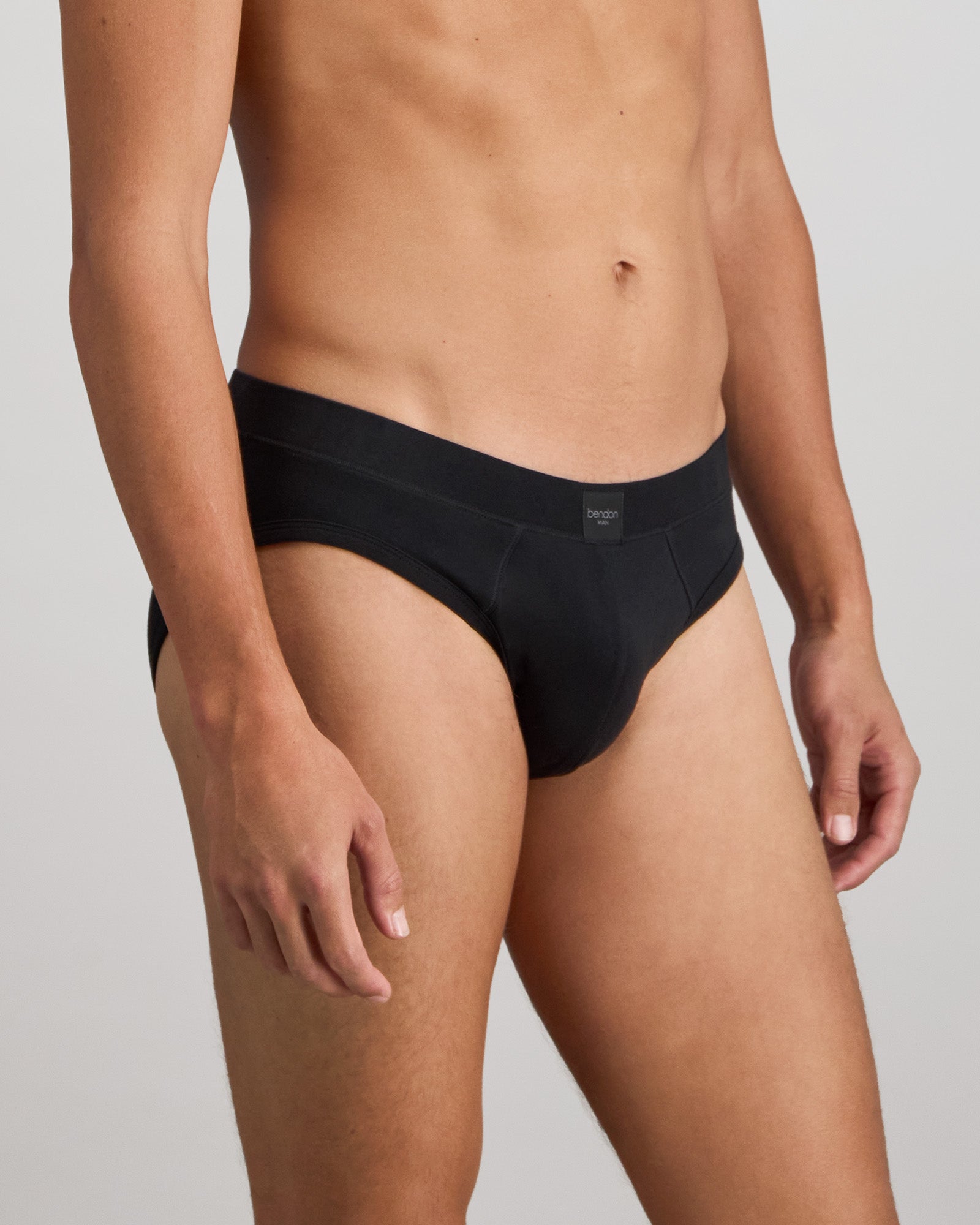 Model wears High Tech Cotton Mens Brief in BLACK. On body side view