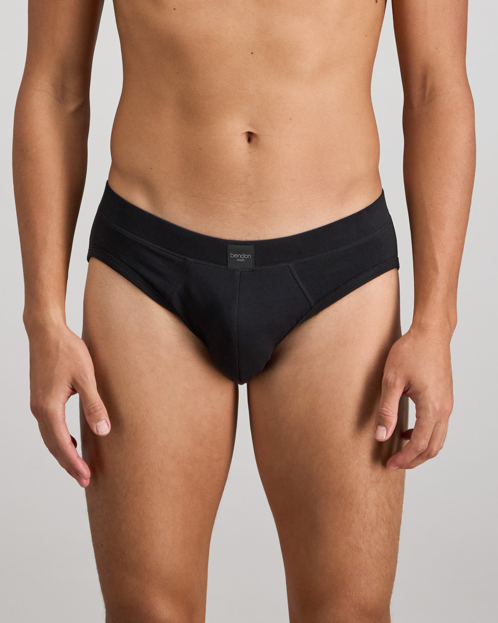 Model wears High Tech Cotton Mens Brief in BLACK. On body front view