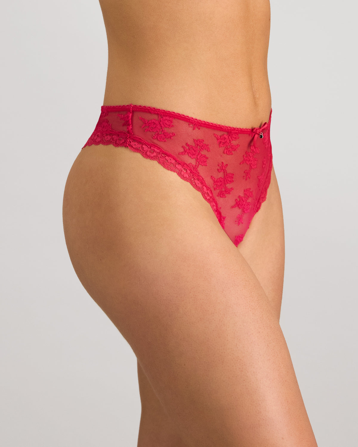Model wears Light Lace Thong in JAZZY. On body side view