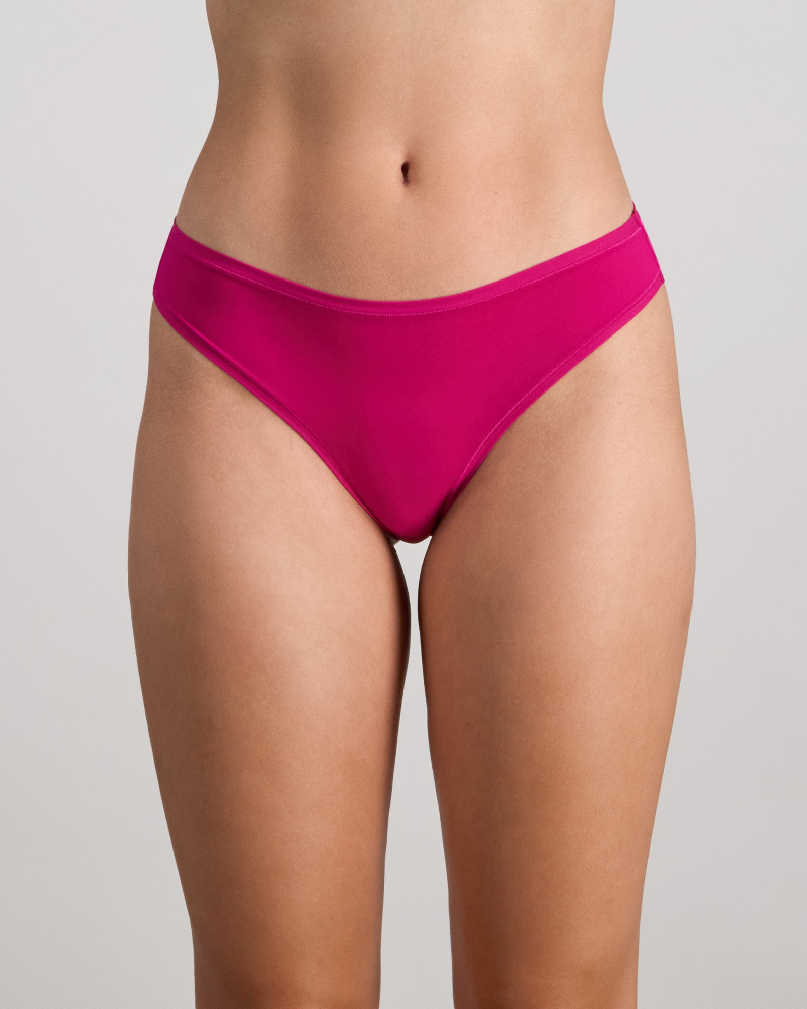 Model wears Extra-Ordinary Thong in FANTASY FUCHSIA. On body front view