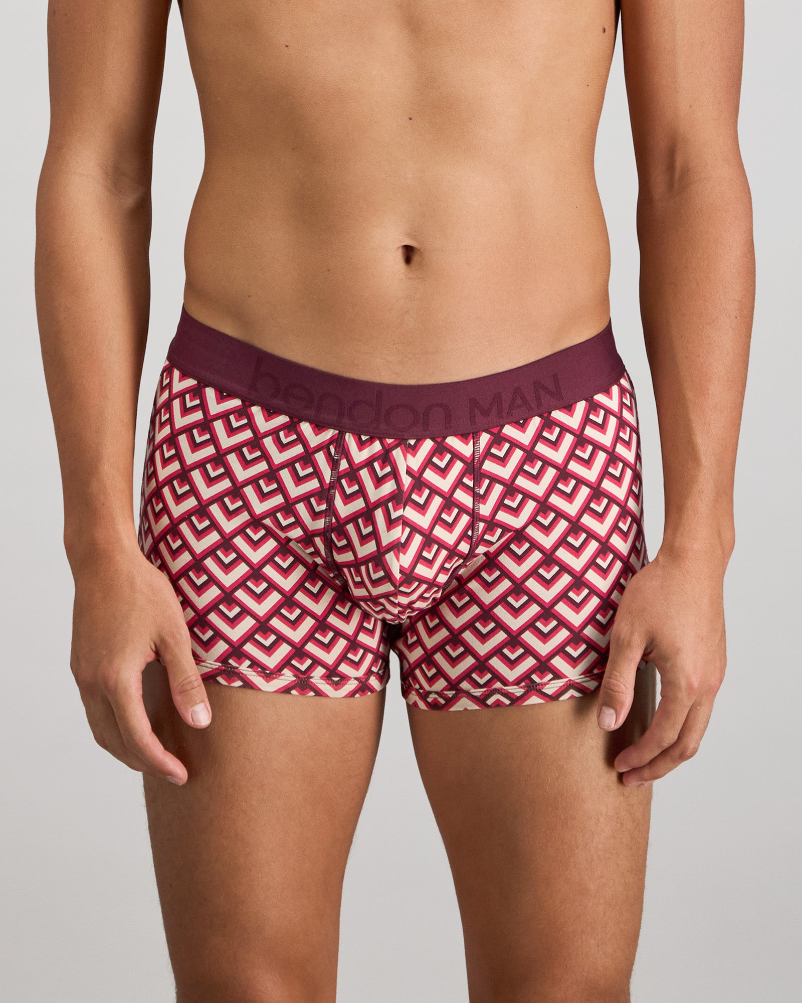 Model wears Retros Print Mens Trunk in ART TILE PRINT. On body front view