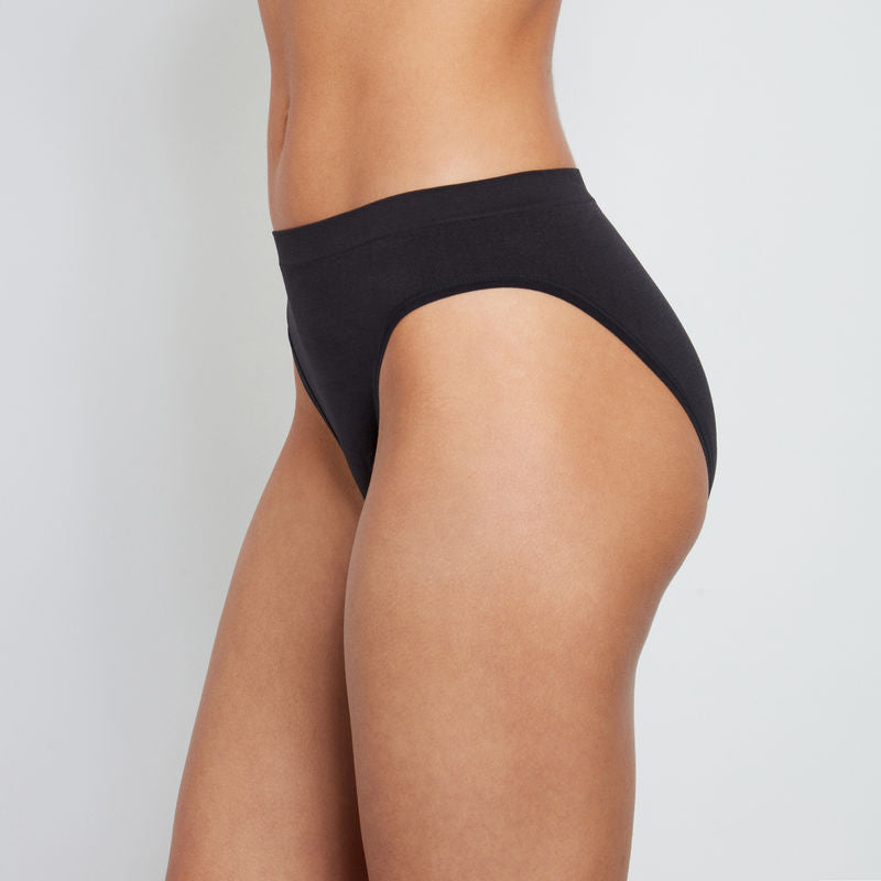 Model wears Seamless High Cut Brief in BLACK. On body side view