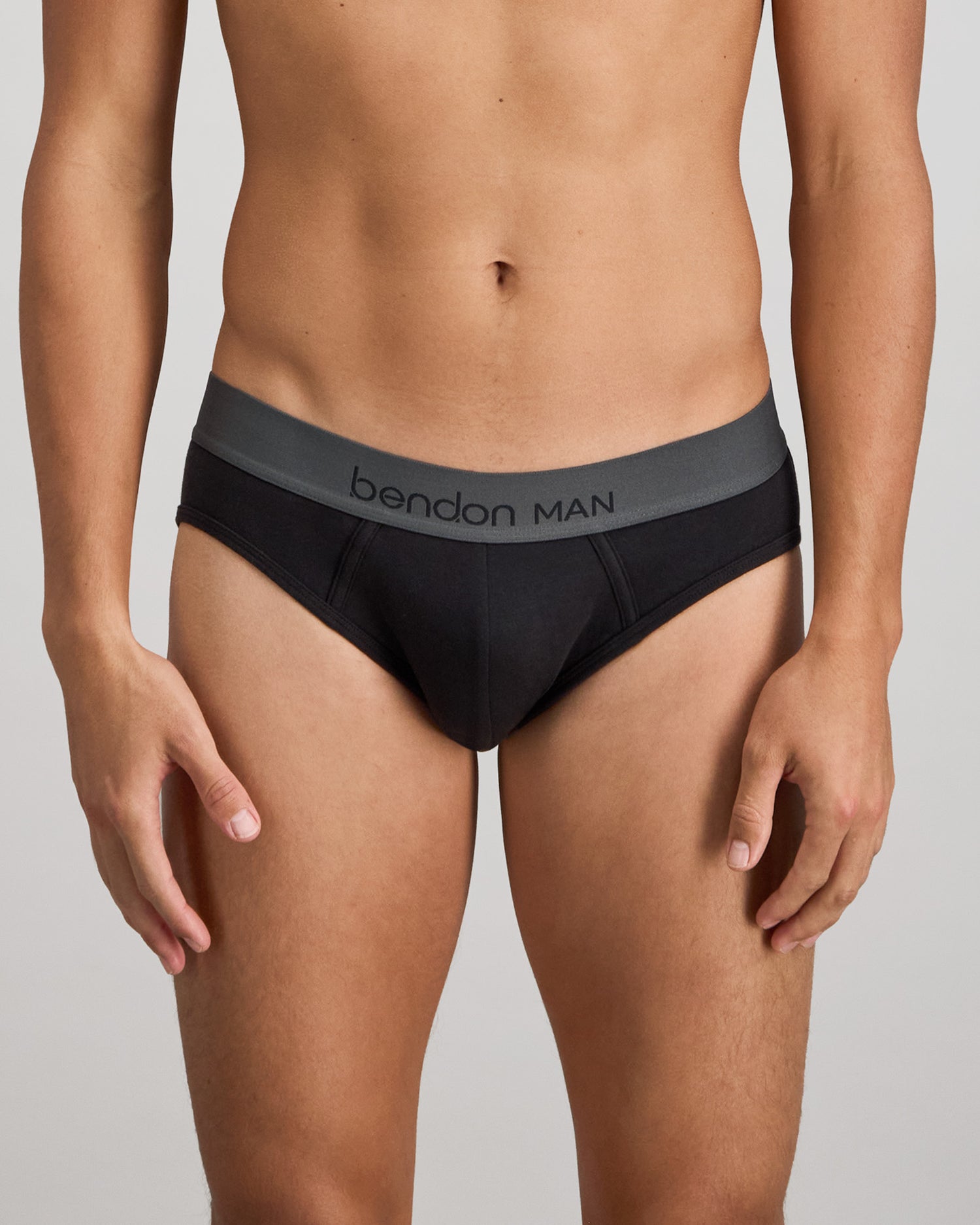 Model wears Cotton Low-Rise Mens Brief in BLACK. On body front view