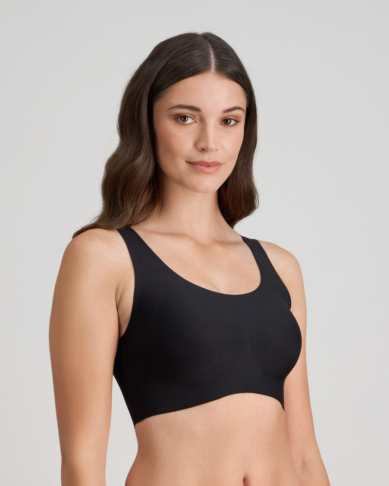 Model wears Comfit Collection Crop Top in BLACK. On body side view