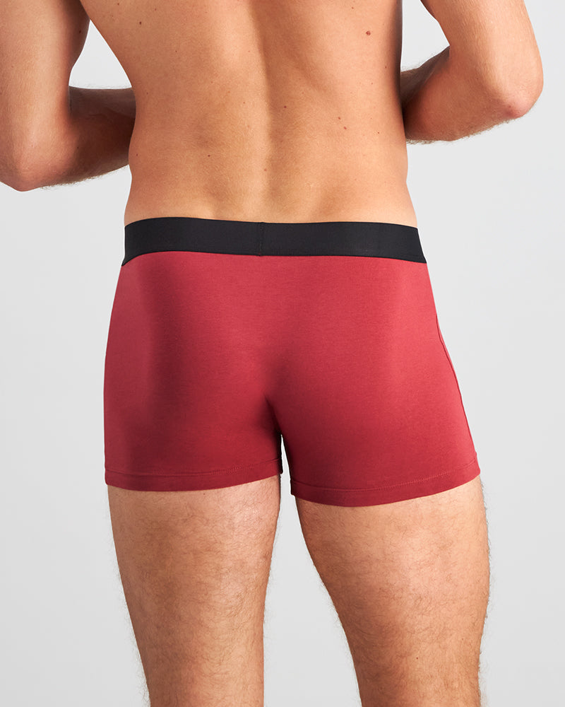 Model wears Everyday Essential Mens Trunk in TIBETAN RED. On body back view