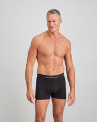 Model wears Cotton Classics Mens Trunk in BLACK. On body front view