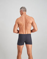 Model wears Cotton Stretch Mens Trunk in NAVY/WHITE. On body back view