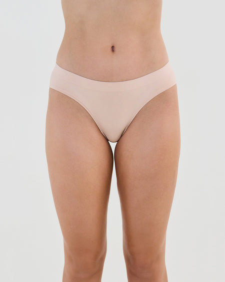 Model wears Seamless Soft Bikini in LATTE. On body front view