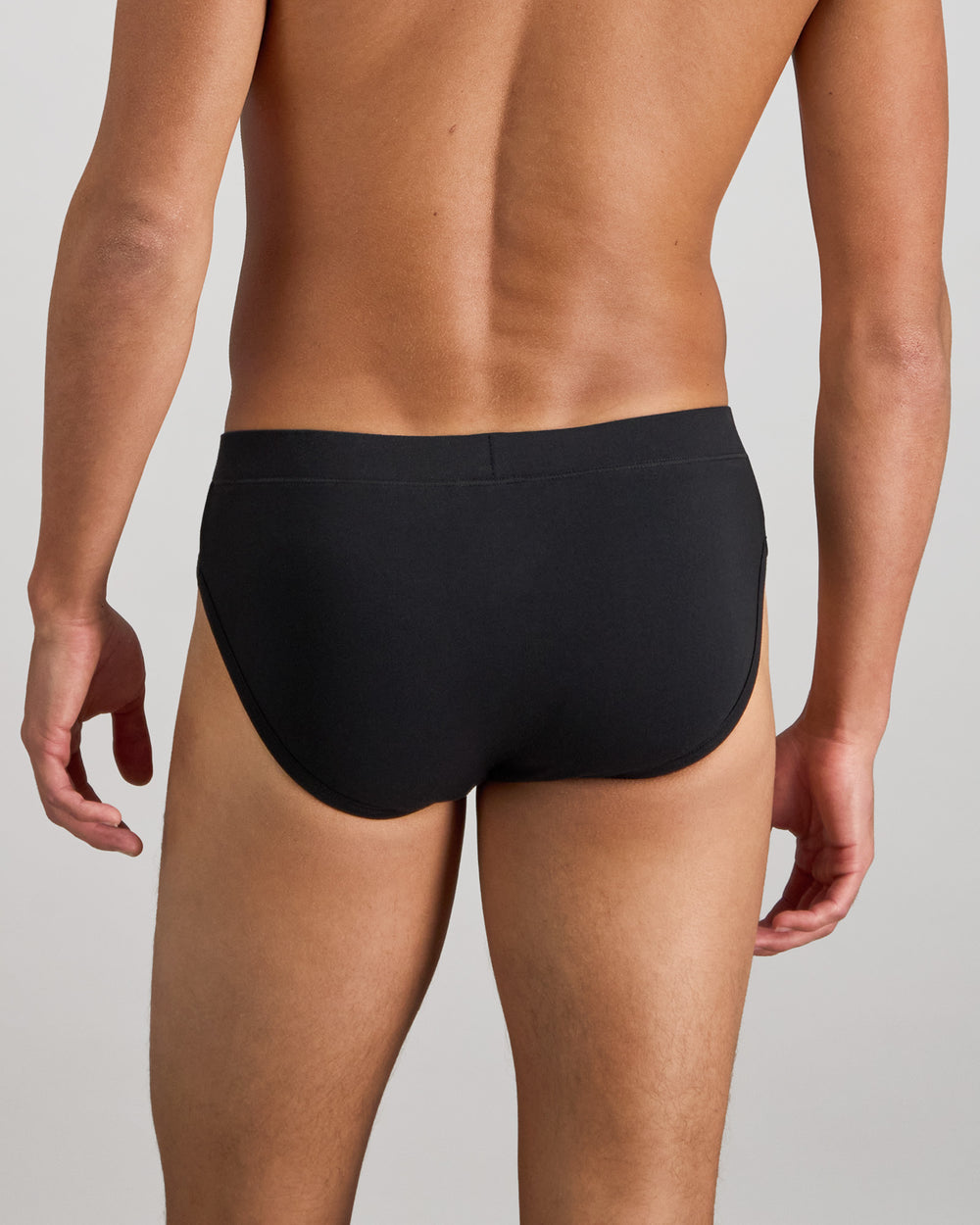 Model wears High Tech Cotton Mens Brief in BLACK. On body back view