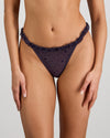 Model wears Wrapped In Stardust Thong in PURPLE VELVET. On body front view