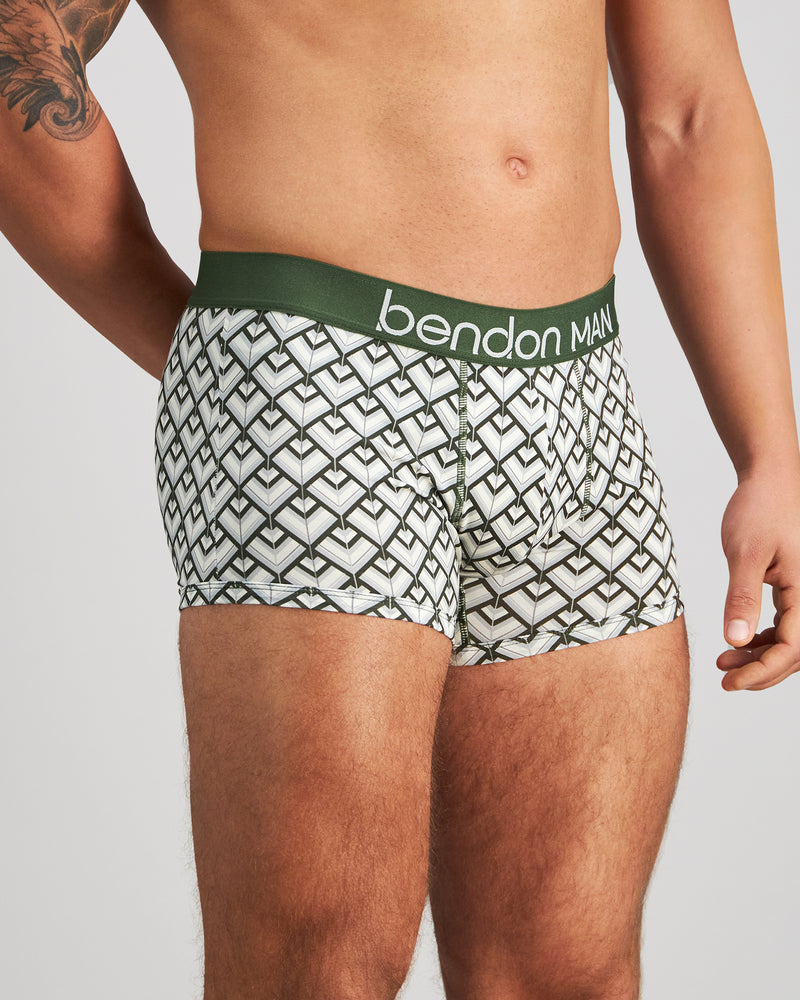 Model wears Retros Print Mens Trunk in ART DECO TILE PRINT. On body side view