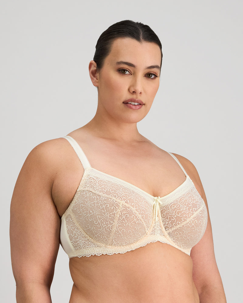 Model wears Delicate Lace Underwire Bra in IVORY/CREAM TAN. On body side view