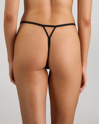 Model wears Lost Paradise Thong in BLACK PRINT. On body back view