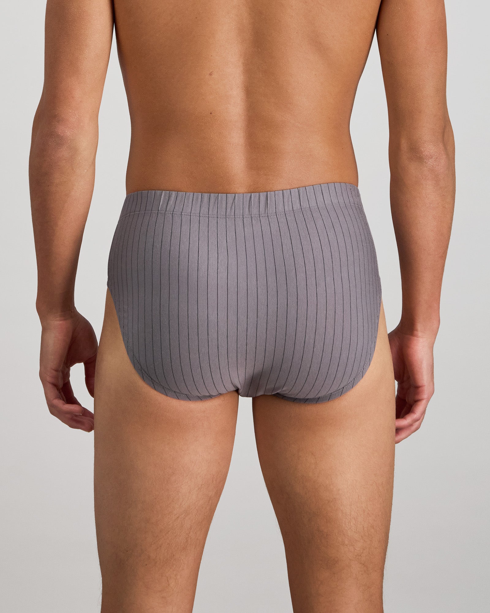 Model wears Cotton Stretch Mens Brief in ASH PINSTRIPE. On body back view