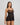 Model wears Oasis Glow Babydoll in BLACK. On body side view