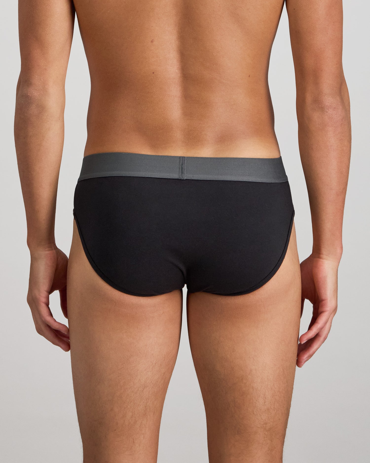 Model wears Cotton Low-Rise Mens Brief in BLACK. On body back view