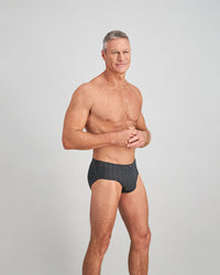 Model wears Cotton Stretch Mens Brief in CHAR BLACK. On body side view
