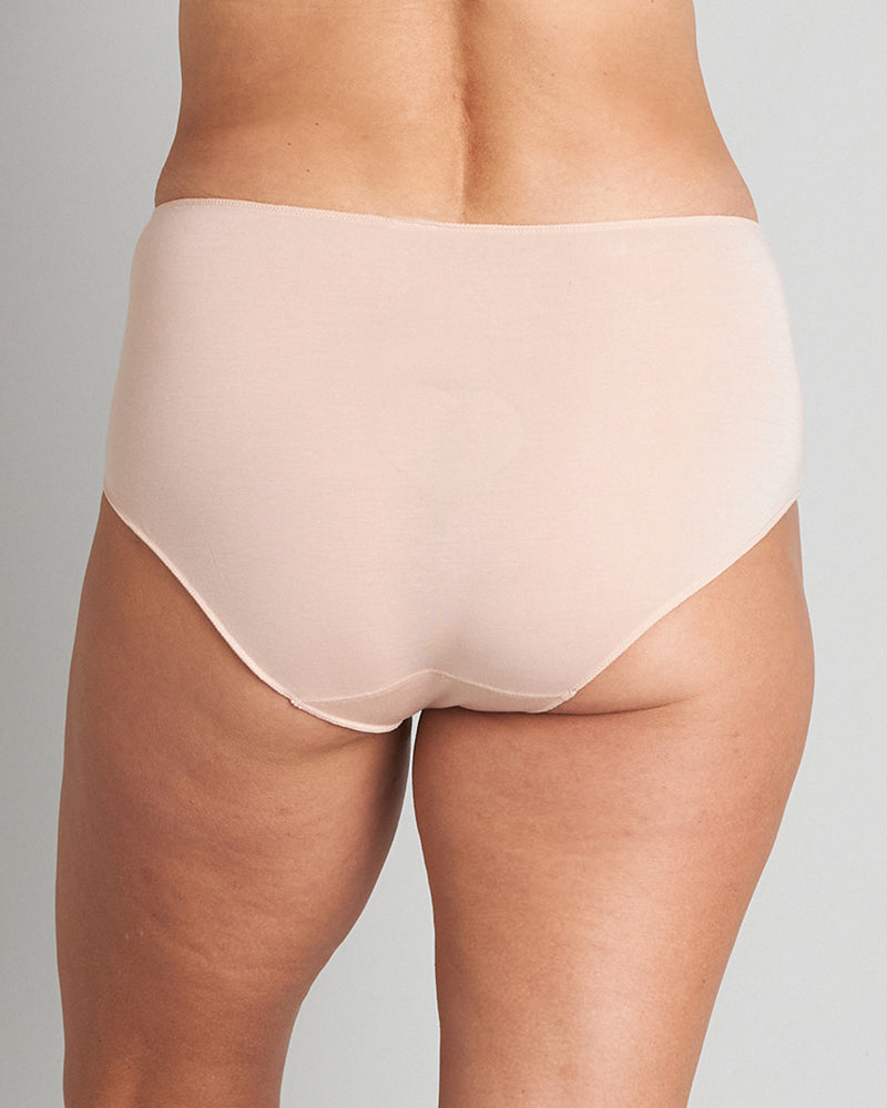 Model wears Au Naturel Full Brief in LATTE. On body back view