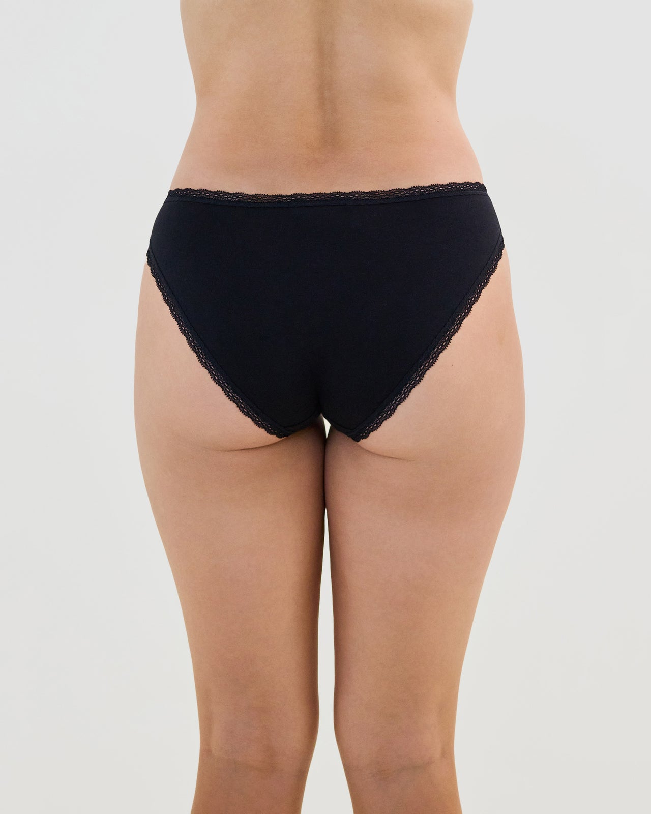 Model wears Stretch Cotton Bikini in BLACK. On body back view
